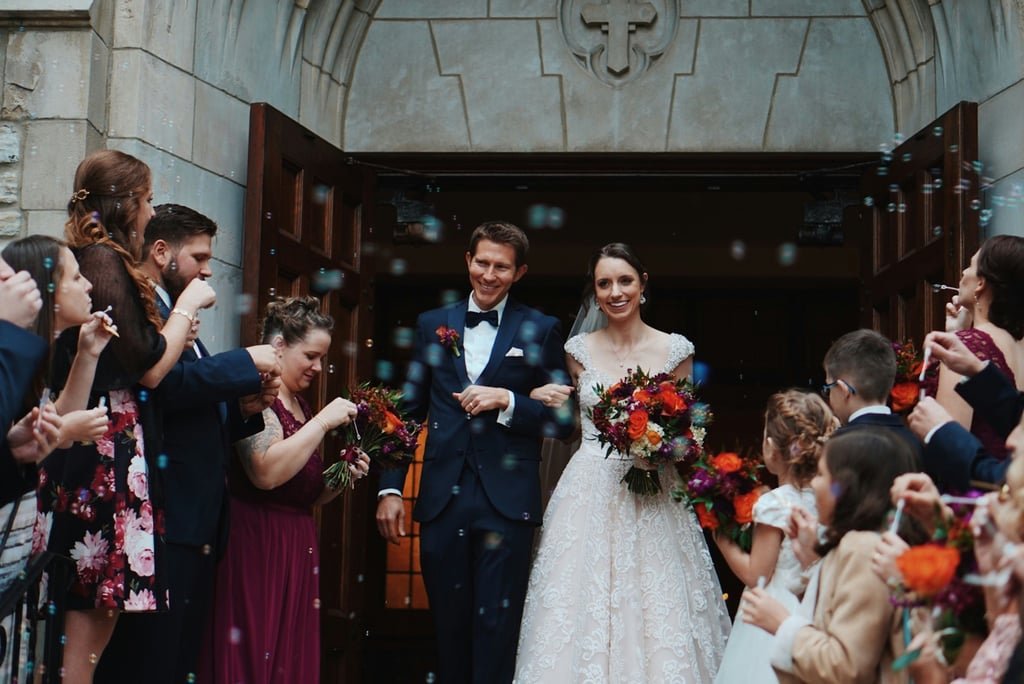 Newlyweds celebrated by family outside a chapel